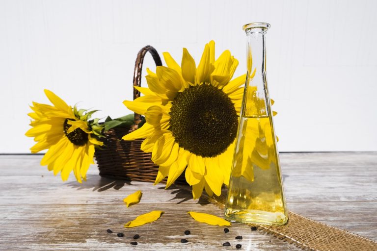Bottle of refined sunflower oil beside sunflowers